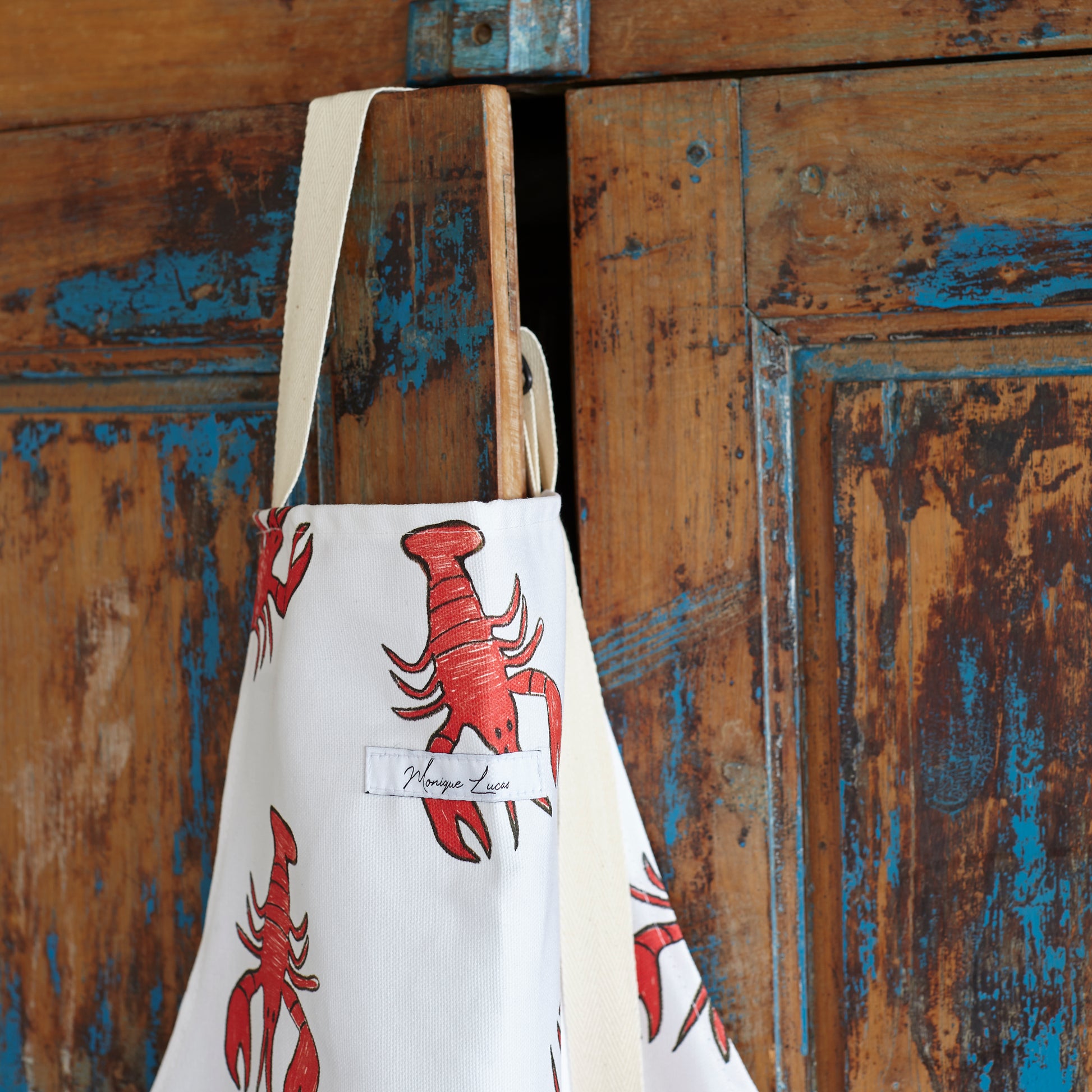 Lobster print apron close up on cuboard door 